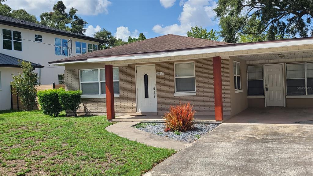 A single-story brick house with a front porch, carport, and a small landscaped yard — 3817 W SAN RAFAEL STREET, TAMPA, FL