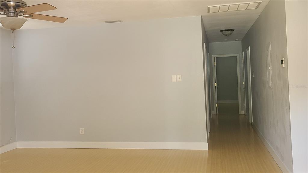 A living room with light-colored walls, wood-look flooring, and a ceiling fan — 3817 W SAN RAFAEL STREET, TAMPA, FL