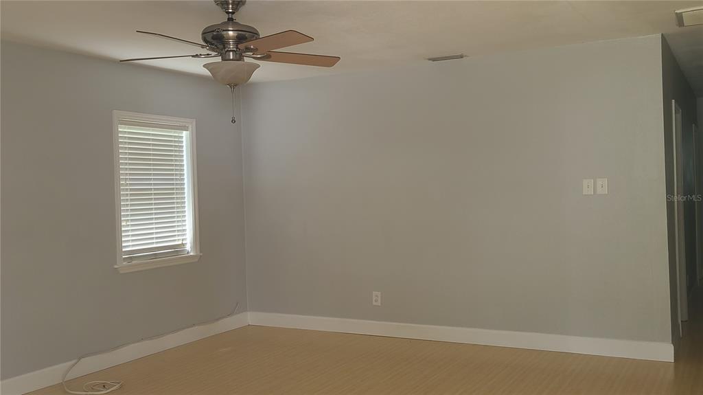 A room with light gray walls, wood-look flooring, a ceiling fan, and a window — 3817 W SAN RAFAEL STREET, TAMPA, FL