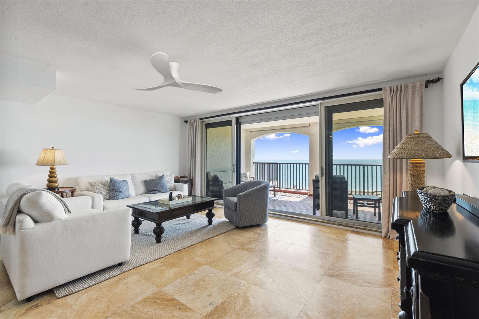 A living room with white furniture, tile floors, and a balcony overlooking the ocean — 4561 NE Ocean Drive # 29, Jensen Beach FL 34957, JENSEN BEACH, FL