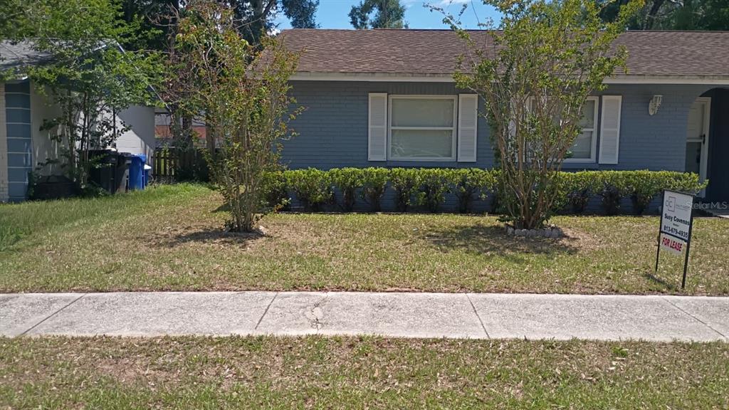 A gray brick house with white shutters and a front yard with two small trees — 721 REGENT CIRCLE S, BRANDON, FL