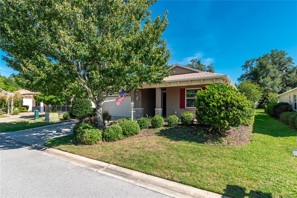 A single-story house with a tan exterior, a front-facing garage, and a large shade tree — 7847 SW 82ND PLACE, OCALA, FL
