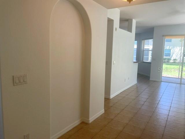 An interior view shows a tiled floor, an arched wall niche, and a sliding glass door — 4270 VICENZA DRIVE UNIT B40, VENICE, FL
