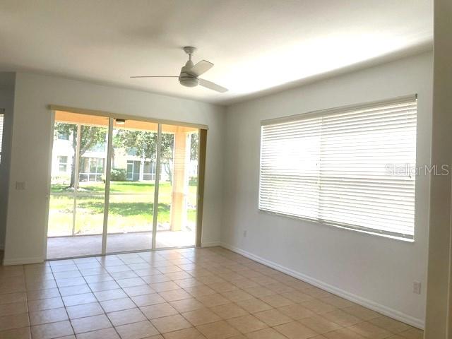 A room with tile flooring, a ceiling fan, sliding glass doors, and horizontal window blinds — 4270 VICENZA DRIVE UNIT B40, VENICE, FL