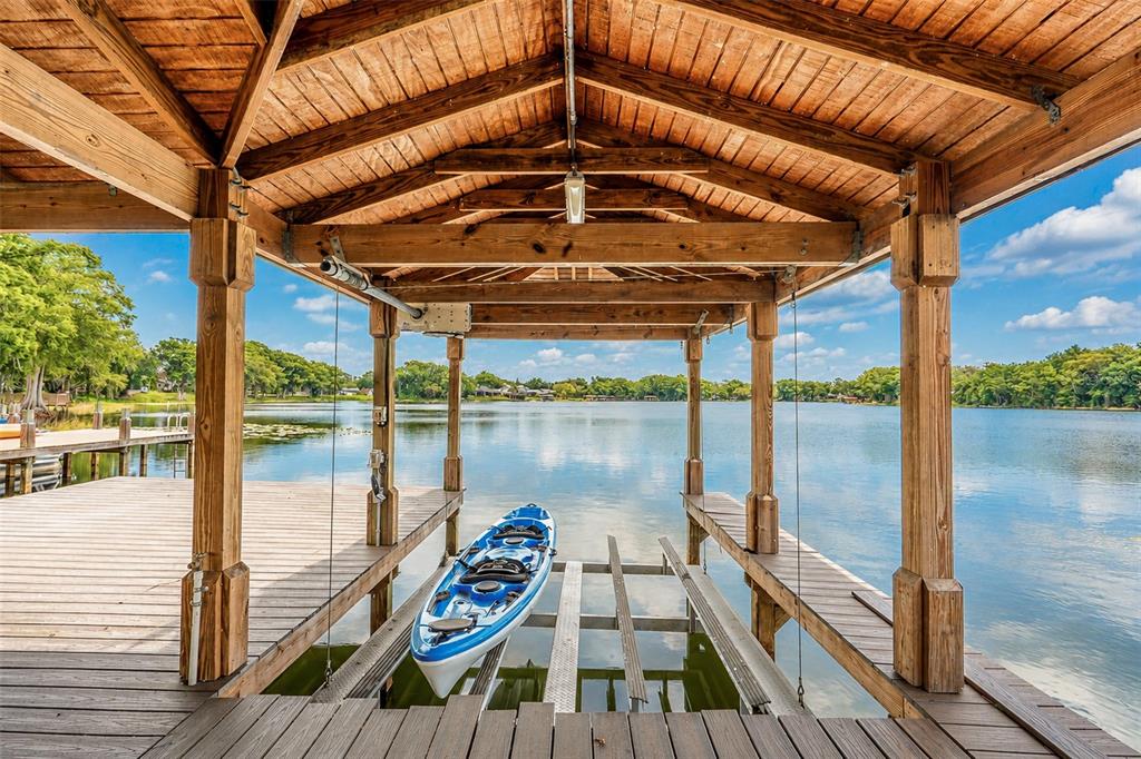 A wooden boat dock with a covered slip and a blue kayak on a lift — 2914 REEF KNOT PLACE, WINTER PARK, FL