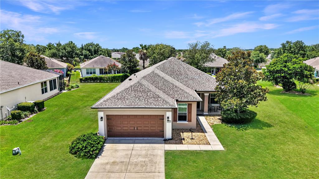 An aerial view of a single-story suburban house with a brown garage and shingled roof — 9824 SW 72ND LANE, OCALA, FL