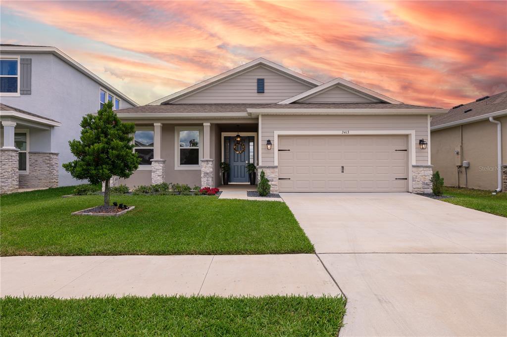 A single-story suburban house with a beige exterior, stone accents, and a two-car garage — 3413 IVY HOLLOW DRIVE, PLANT CITY, FL