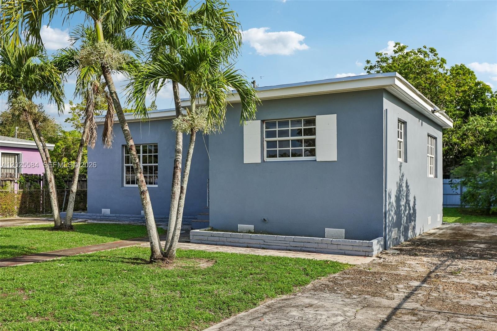 A room with wood-look flooring, white walls, a ceiling fan, and doorways leading to other areas — 1045 NW 115th St, Miami FL 33168, MIAMI, FL