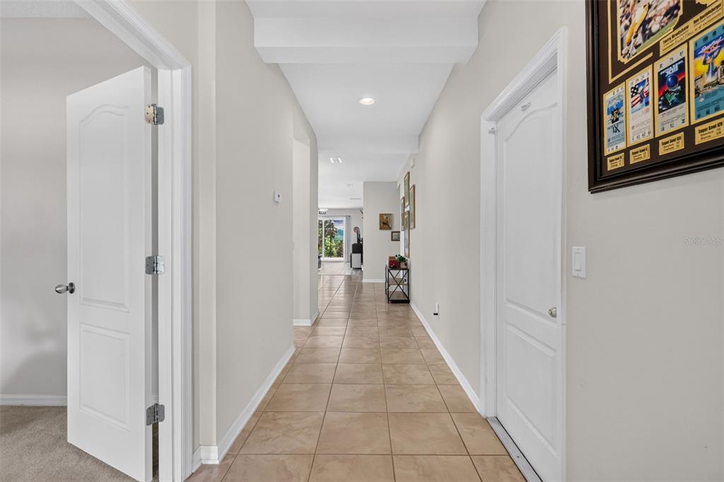 A tiled hallway leads from a foreground area toward a bright room with exterior views — 3115 ZANDER DRIVE, GRAND ISLAND, FL