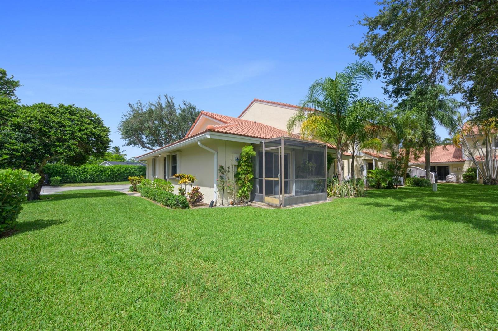 A beige house with a red tile roof and a screened-in patio sits on grass — 6371 Boca Circle, Boca Raton FL 33433, BOCA RATON, FL