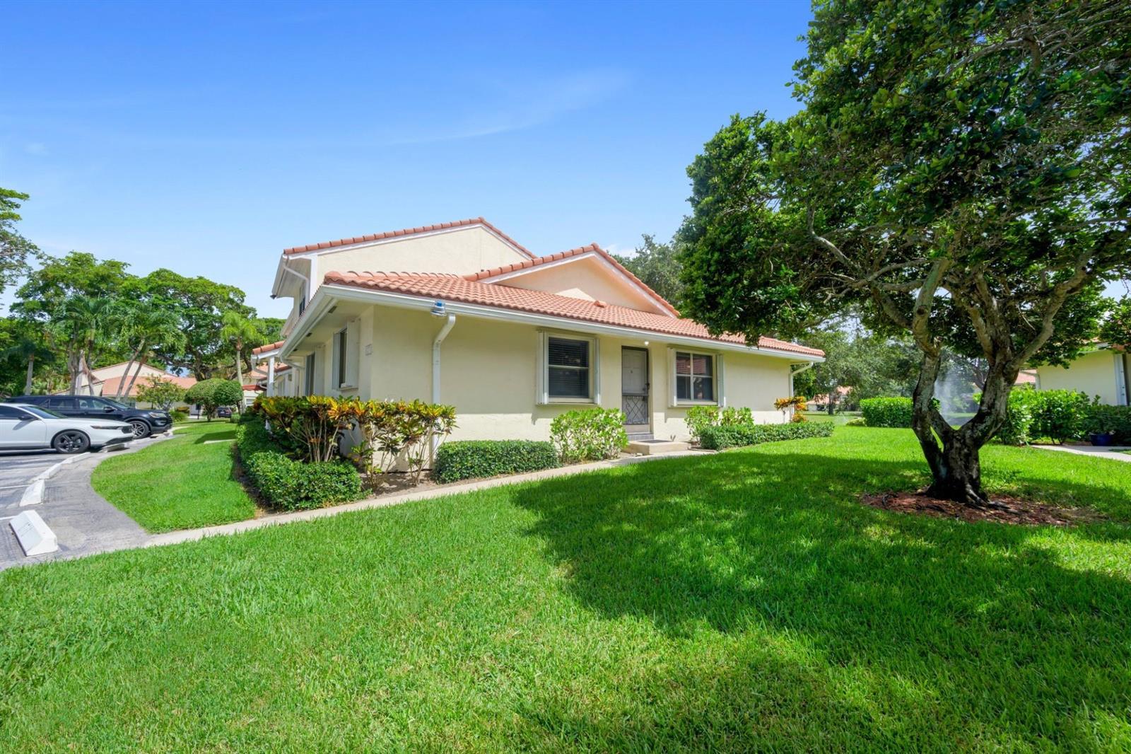 A light-colored, single-story residential building with a tiled roof sits on a grassy lawn — 6371 Boca Circle, Boca Raton FL 33433, BOCA RATON, FL