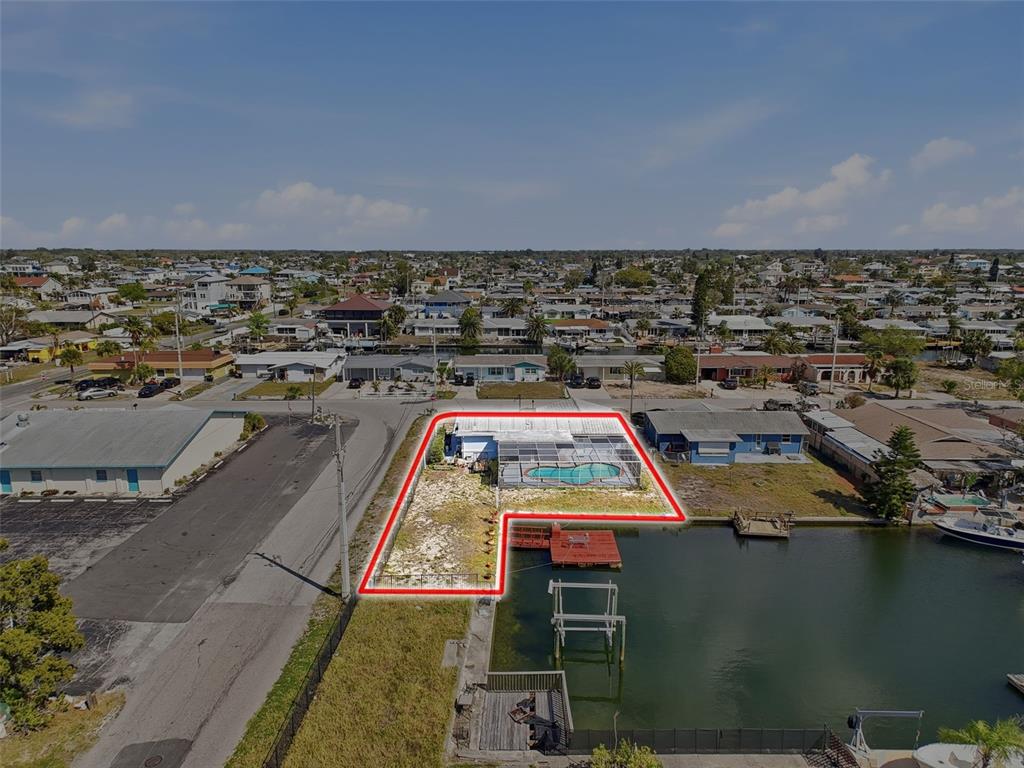An aerial view shows a waterfront house with a pool and dock outlined in red — 13701 VERONICA DRIVE, HUDSON, FL