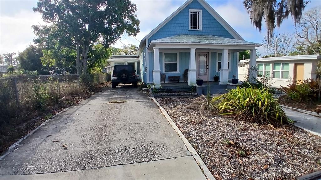 A blue house with a front porch and a concrete driveway sits on a lot — 542 DIVISION STREET, TARPON SPRINGS, FL