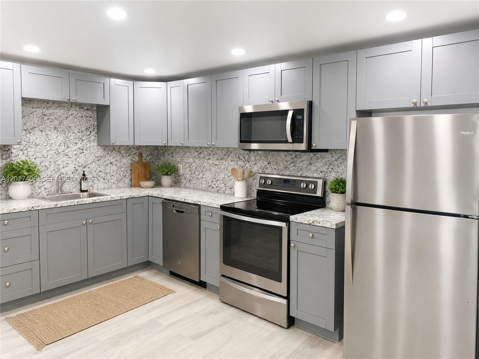 A kitchen features gray cabinets, stainless steel appliances, and a speckled white countertop and backsplash — 14830 Naranja Lakes Blvd, Miami FL 33032, MIAMI, FL
