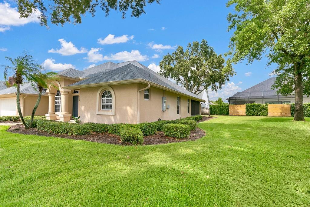 A tan stucco house with a gray shingled roof and a manicured lawn — 1525 DATE DRIVE DRIVE, TITUSVILLE, FL