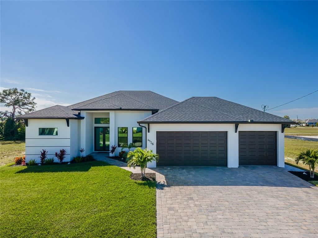 A single-story house with a white exterior, dark roof, and a two-car garage — 4126 NW 39TH STREET, CAPE CORAL, FL