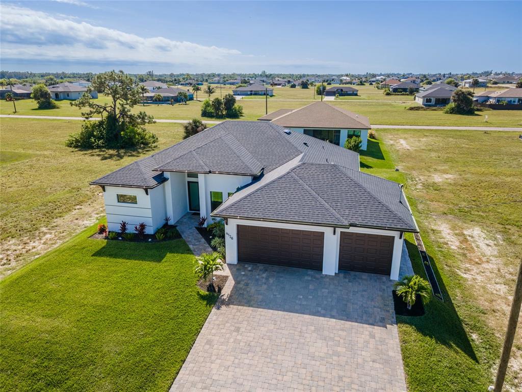 An aerial view of a single-story house with a dark shingled roof and paved driveway — 4126 NW 39TH STREET, CAPE CORAL, FL