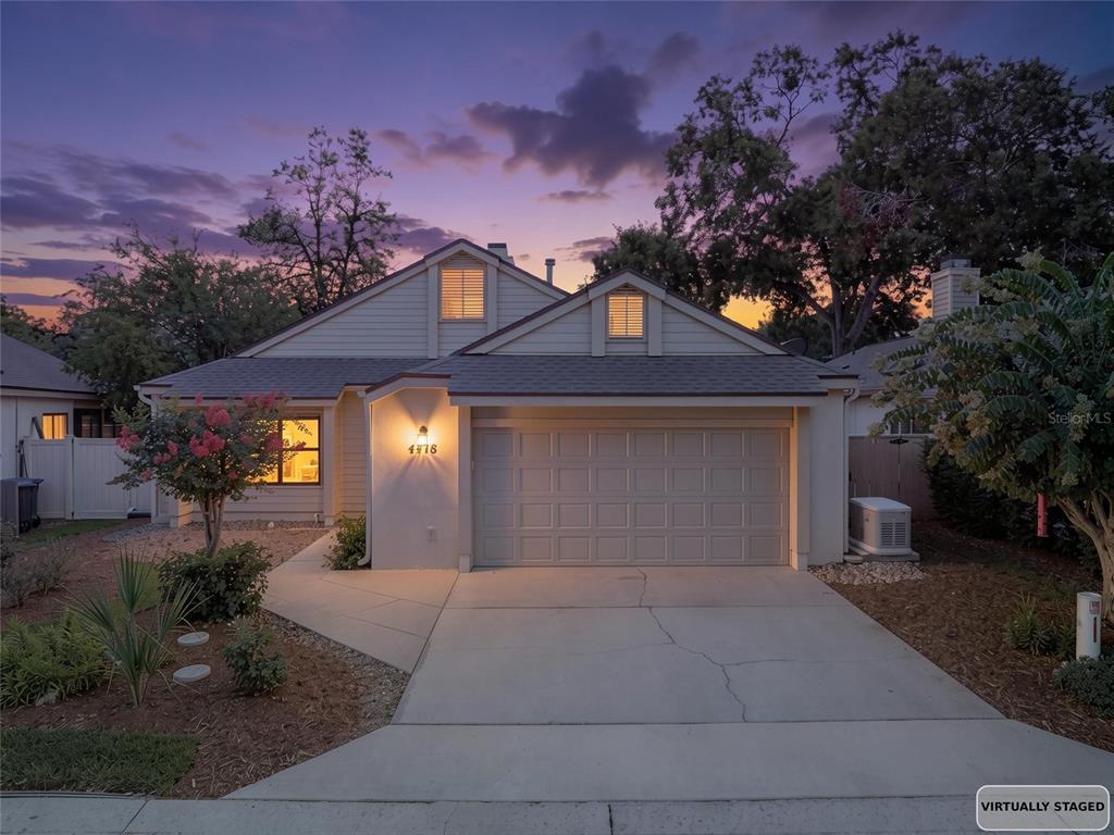 A single-story house with a two-car garage and a concrete driveway at twilight — 4418 NE 4TH STREET, OCALA, FL