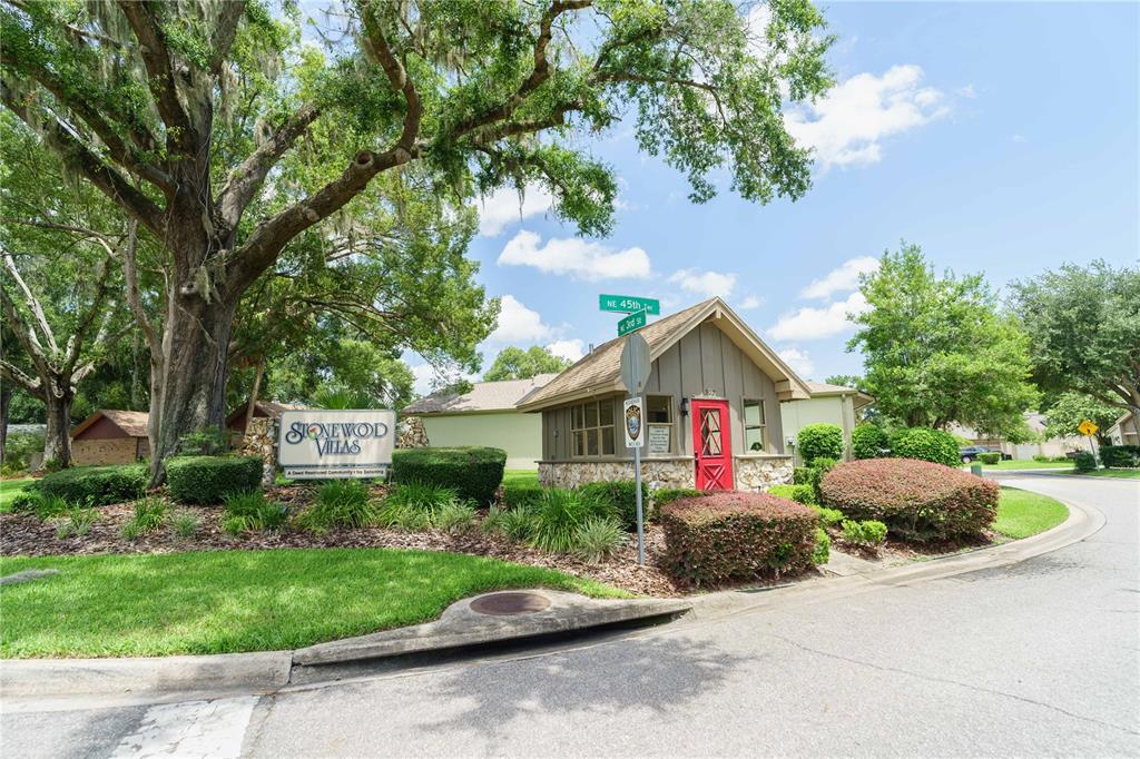 The entrance to Stonewod Villas features a stone sign, a small guardhouse, and large trees — 4418 NE 4TH STREET, OCALA, FL