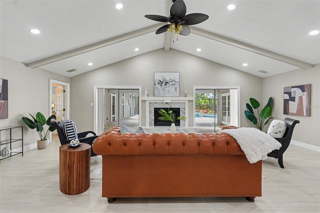 A living room features gray tile flooring, a leather sofa, built-in shelving, and a pool table — 475 HOLLY HILL ROAD, OLDSMAR, FL