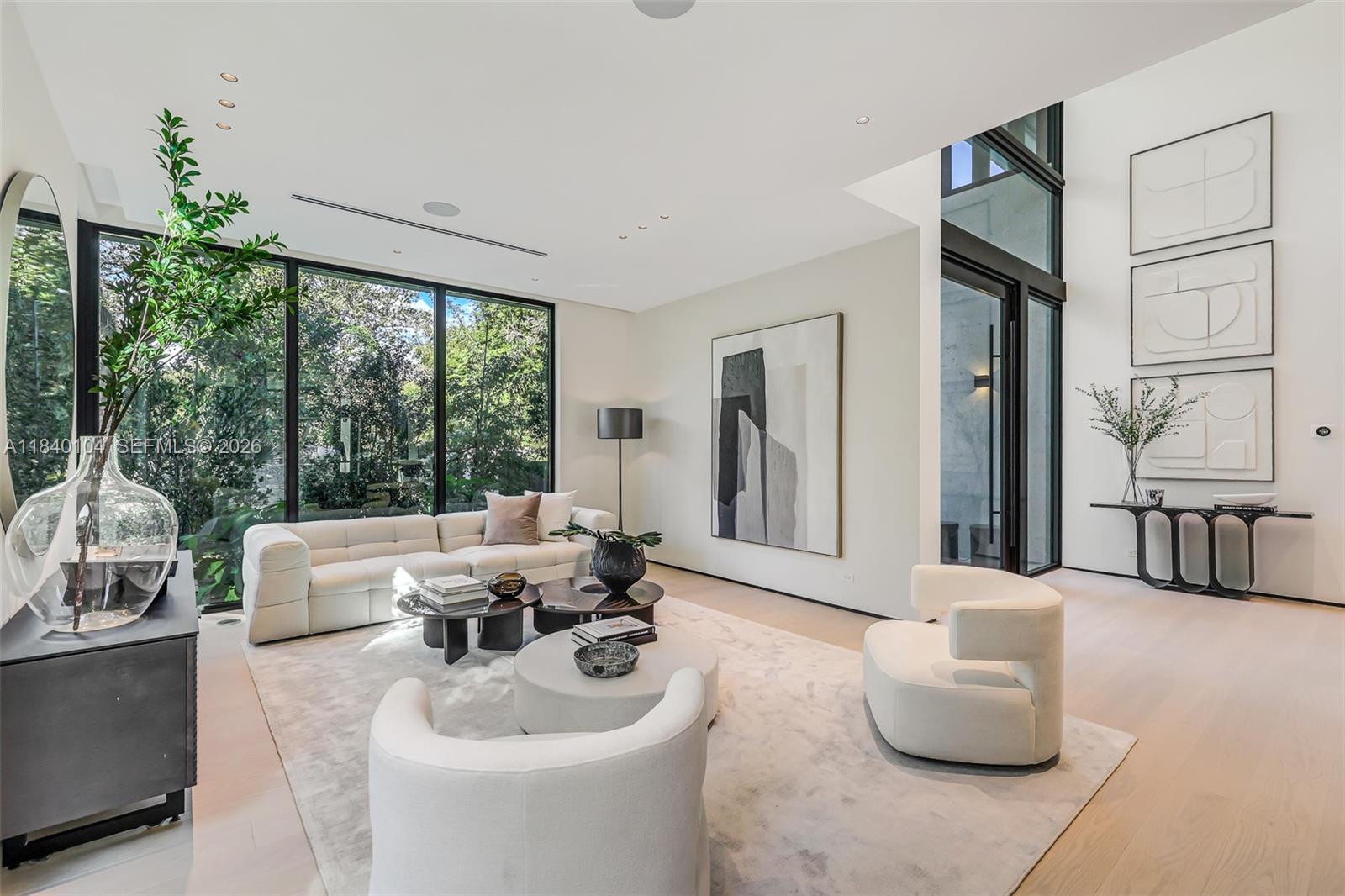 A modern living room features a white sectional, two curved chairs, and floor-to-ceiling windows — 3860 Little Ave, Miami FL 33133, MIAMI, FL