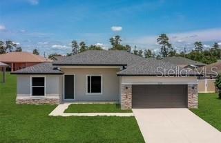 A single-story house with a gray shingled roof, light-colored siding, and a two-car garage — 8719 SW 139TH PLACE, OCALA, FL