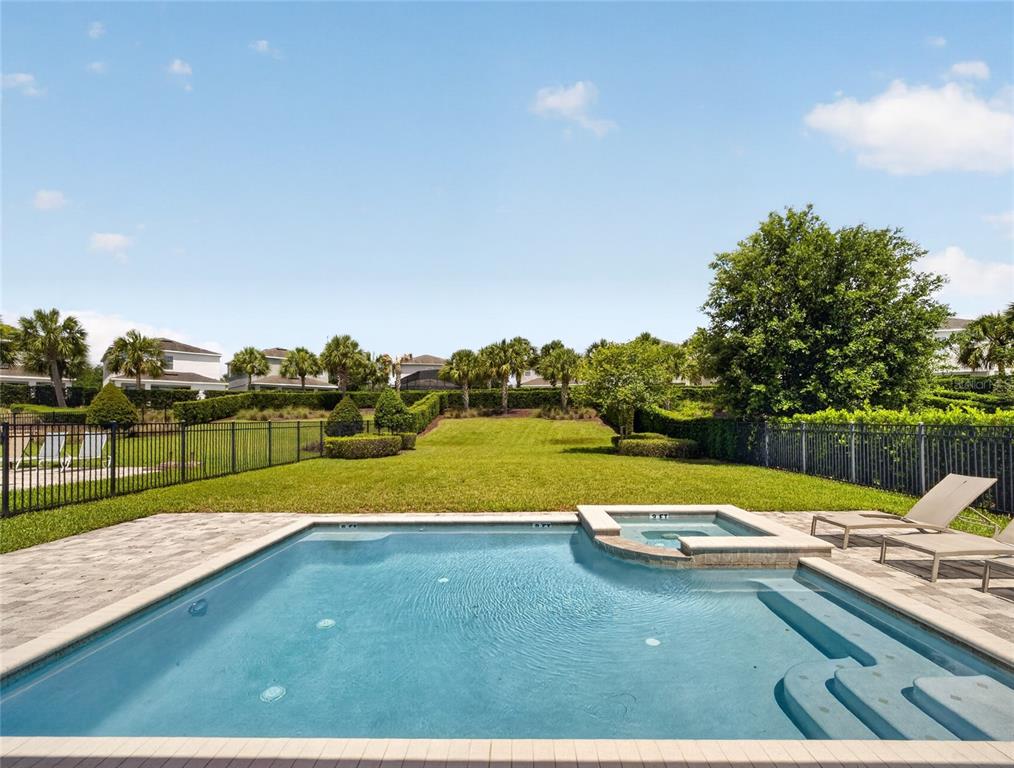 A backyard features a swimming pool with an attached spa and a fenced grassy lawn — 7450 MARKER AVENUE, KISSIMMEE, FL
