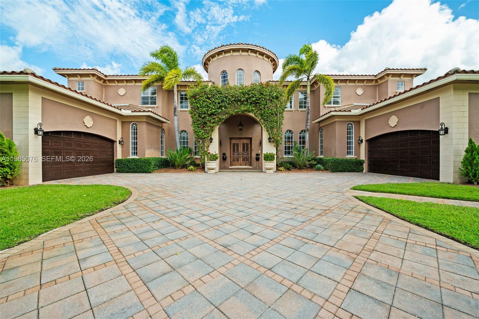 A large two-story Mediterranean-style house features a paved circular driveway and two garage doors — 12821 Kapok Ln, Davie FL 33330, DAVIE, FL