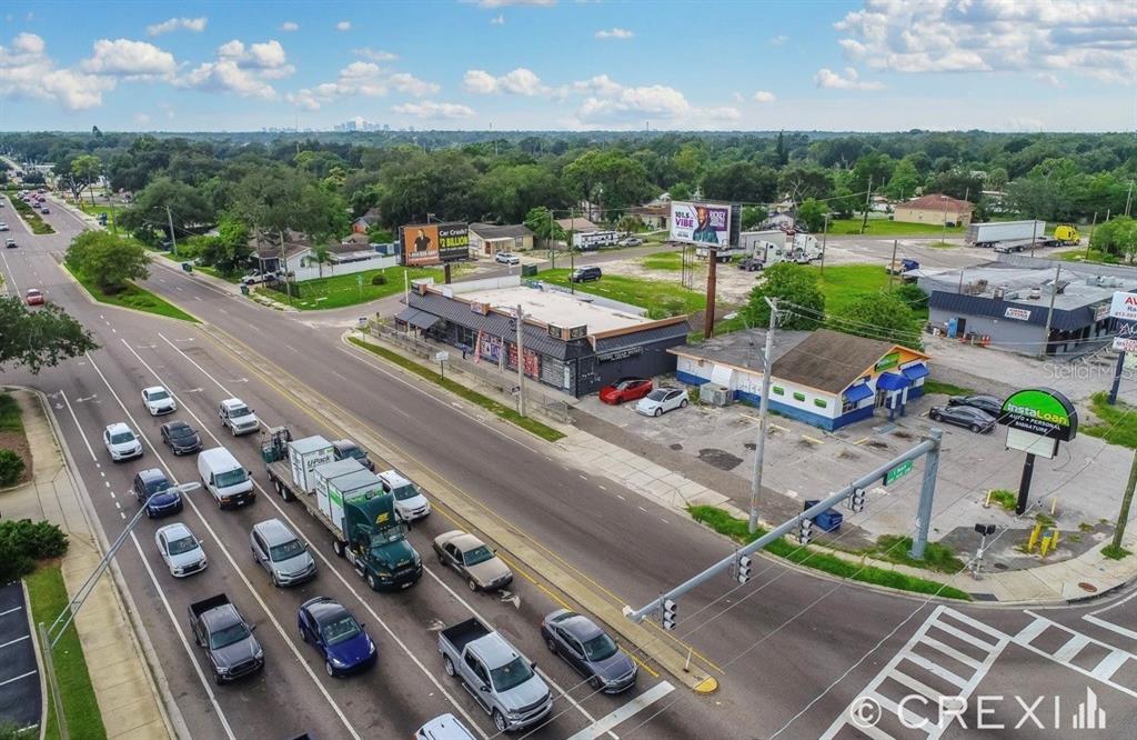 An aerial view shows a commercial intersection with a strip mall, businesses, and traffic — 9002 N 40TH ST, TAMPA, FL