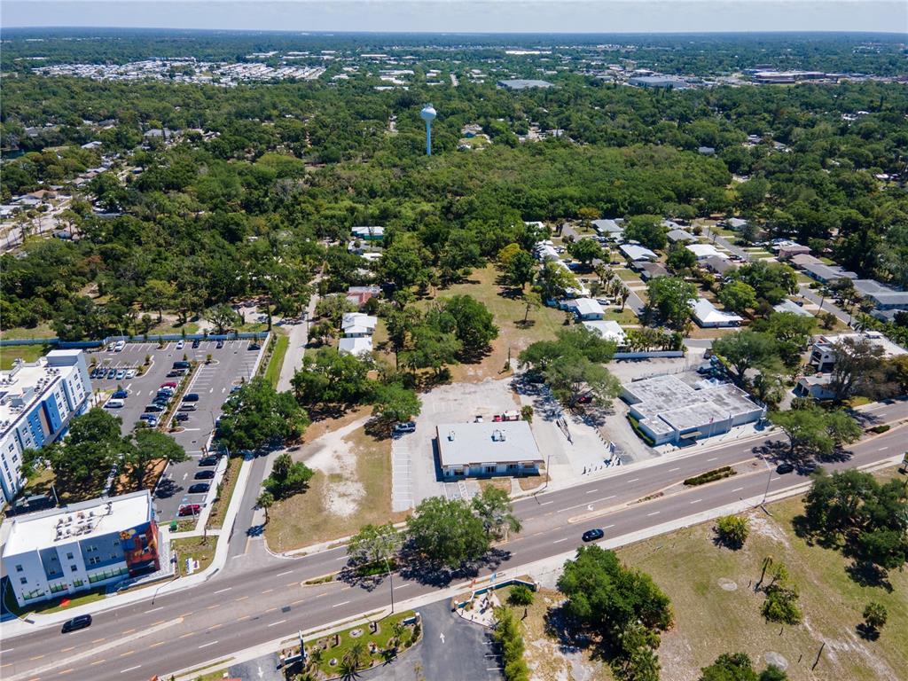 An aerial view shows a commercial building, parking lots, and surrounding residential areas with trees — 4500 N TAMIAMI TRAIL, SARASOTA, FL