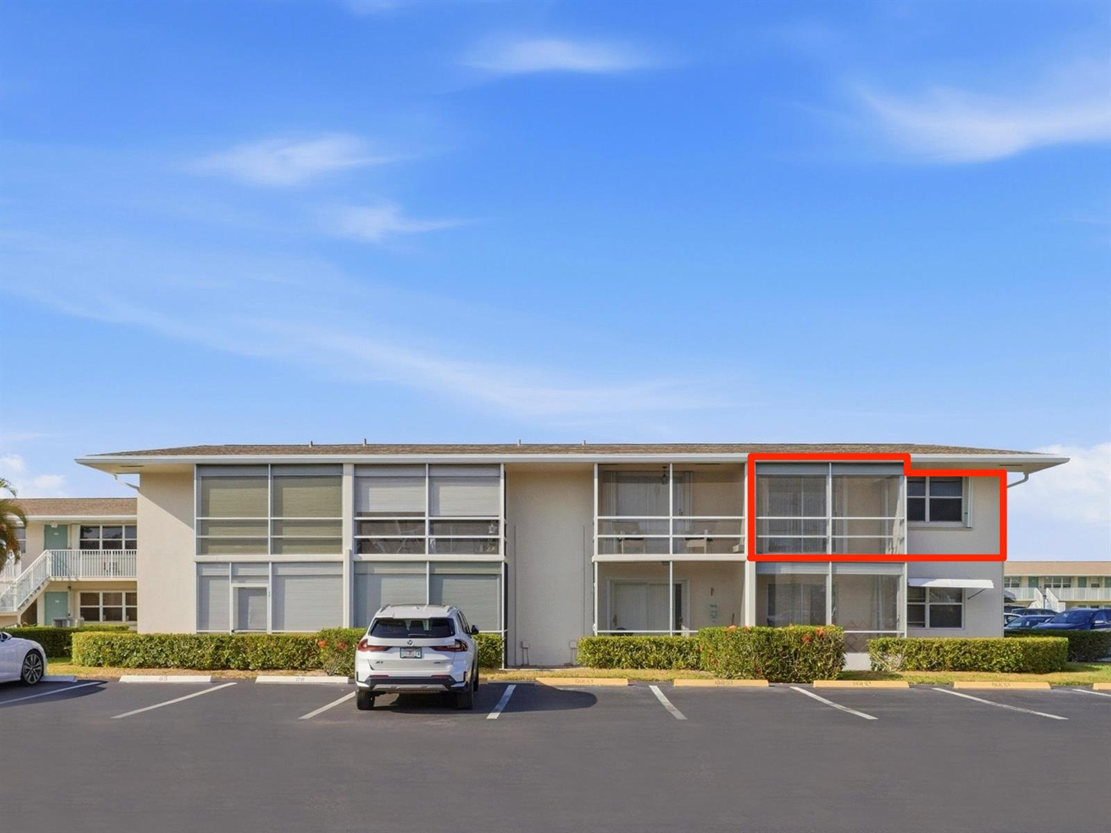 An exterior view of a multi-story apartment building with a red box highlighting a balcony — 680 W Horizons # 212, Boynton Beach FL 33435, BOYNTON BEACH, FL