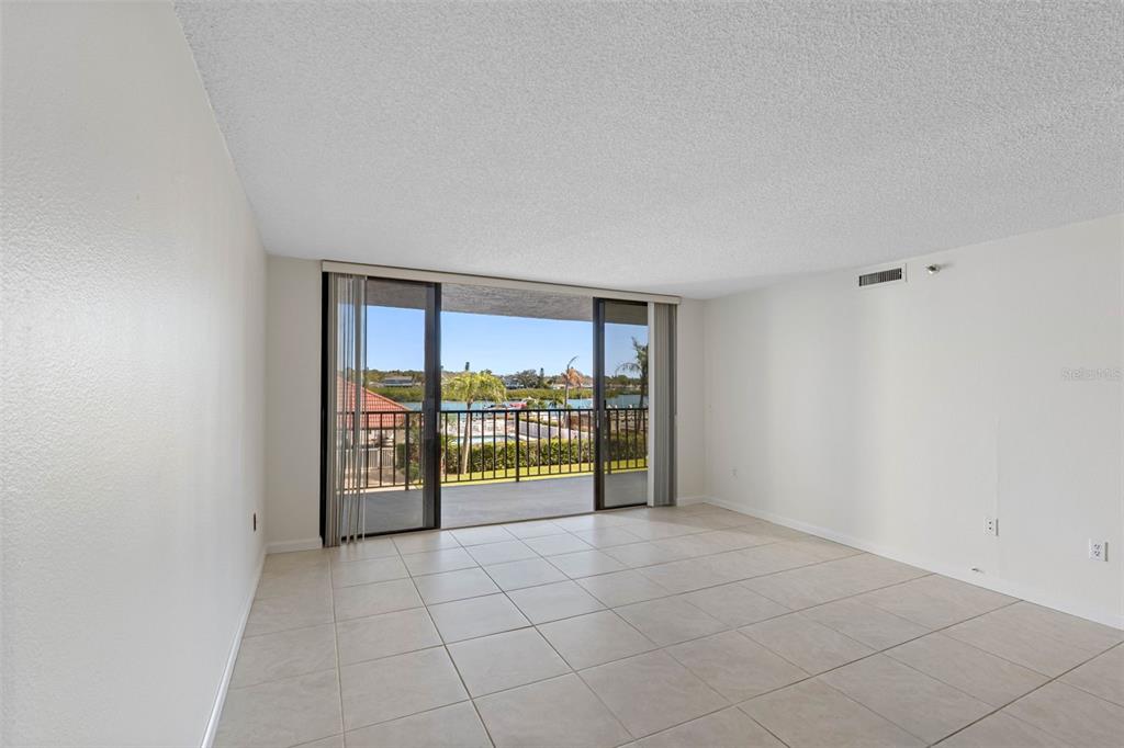 A vibrant sunset illuminates the ocean waves washing onto a sandy beach — 19111 VISTA BAY DRIVE UNIT 204, INDIAN SHORES, FL