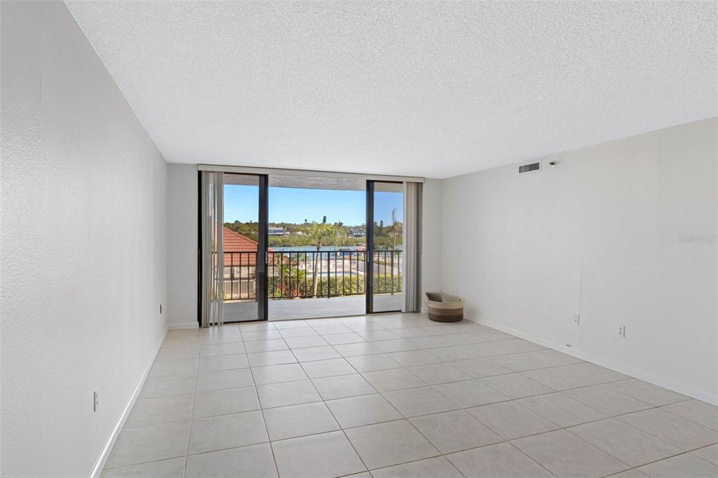A dining area with a glass table and a built-in wine cooler unit — 19111 VISTA BAY DRIVE UNIT 204, INDIAN SHORES, FL