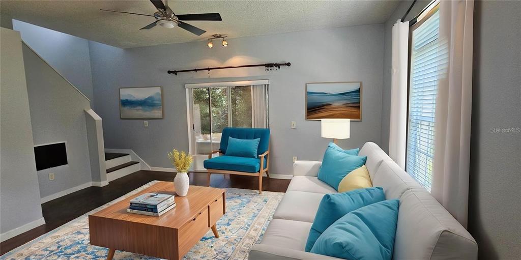 A living room features a white sofa, a blue accent chair, and a wooden coffee table — 4337 DEERMONT CIRCLE, TAMPA, FL