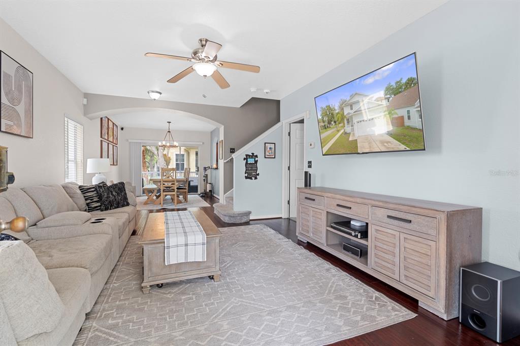 A living room features a sectional sofa, a wooden media console, and a dining area — 7415 S ELLIOTT STREET, TAMPA, FL