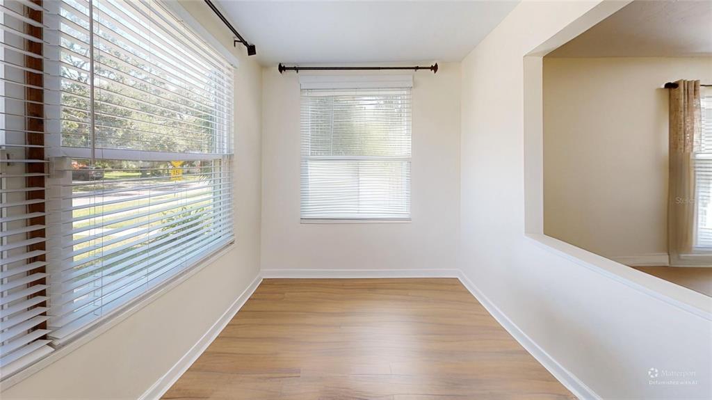 An empty room with light wood-look flooring, white walls, and windows with white blinds — 2235 20TH ST S, ST PETERSBURG, FL