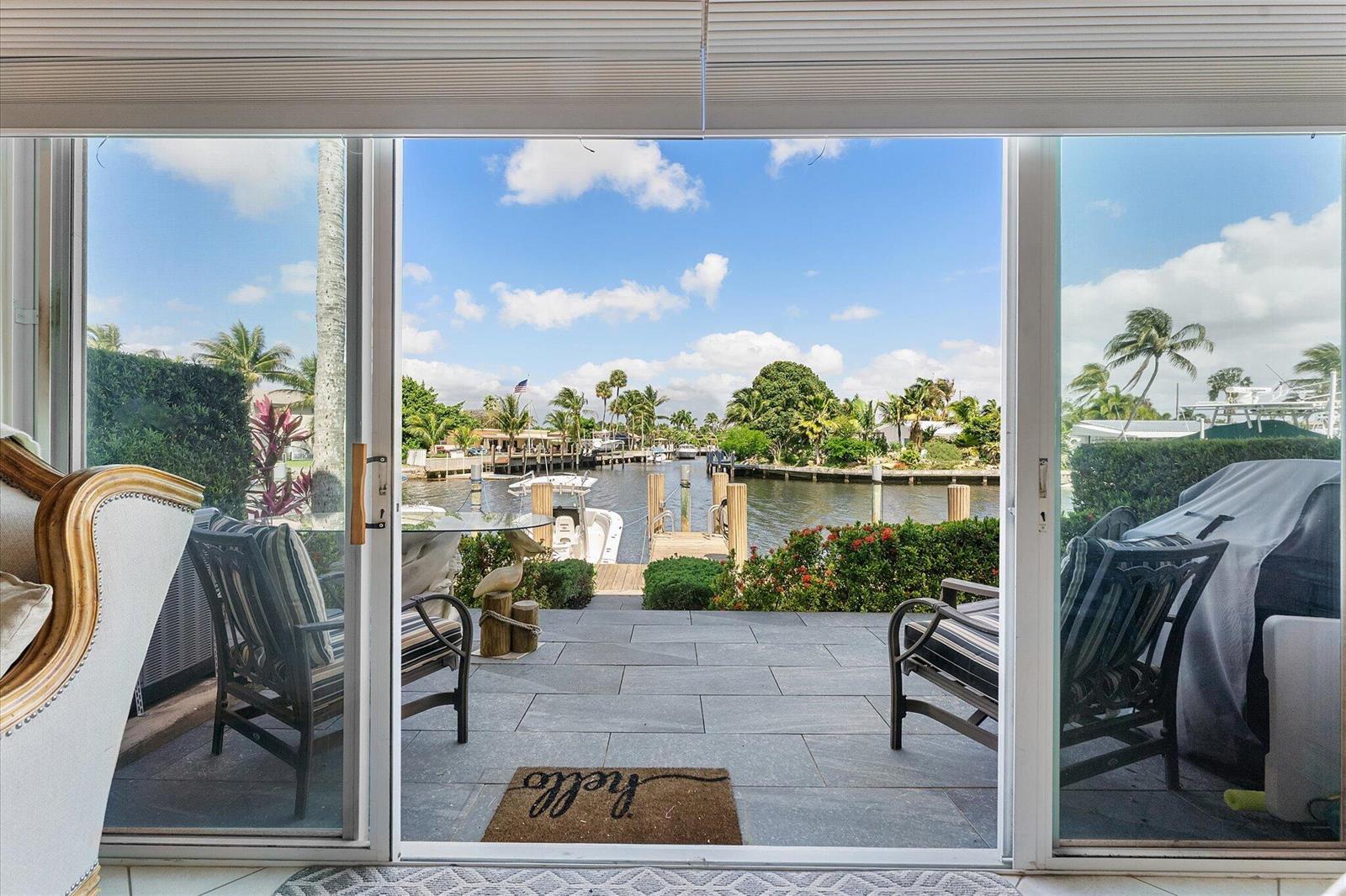 A patio with tile flooring and outdoor furniture overlooks a canal with a boat dock — 1351 SE 3rd Avenue, Pompano Beach FL 33060, POMPANO BEACH, FL