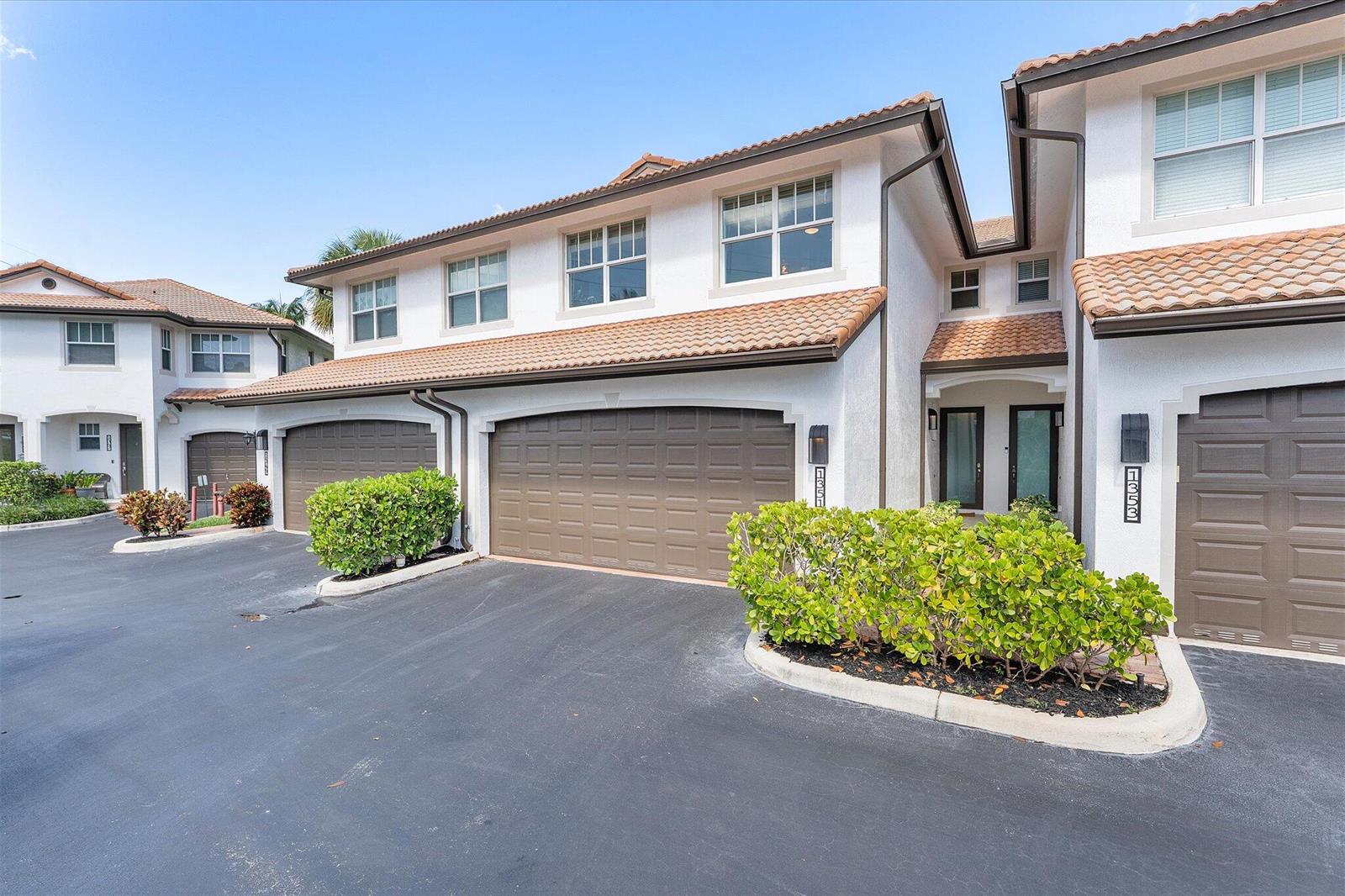 Exterior view of two-story townhomes with brown garage doors and white stucco walls — 1351 SE 3rd Avenue, Pompano Beach FL 33060, POMPANO BEACH, FL