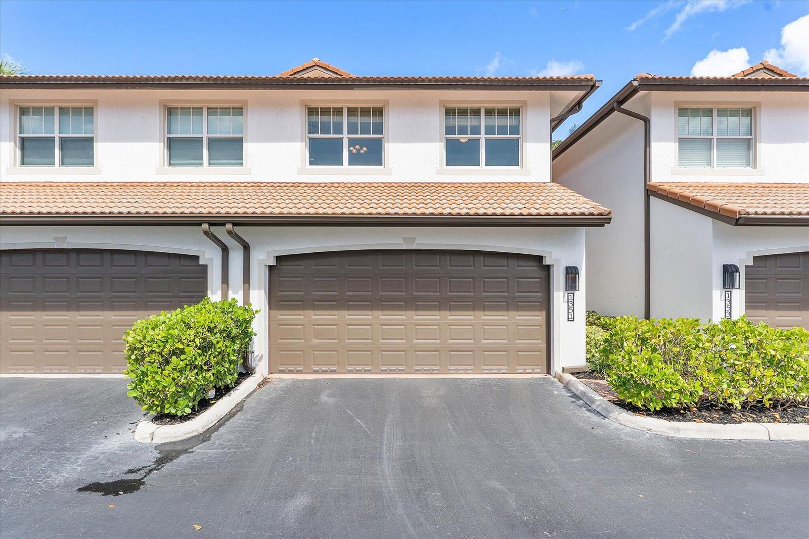 A two-story townhouse exterior features a brown garage door, white stucco walls, and tiled roof — 1351 SE 3rd Avenue, Pompano Beach FL 33060, POMPANO BEACH, FL