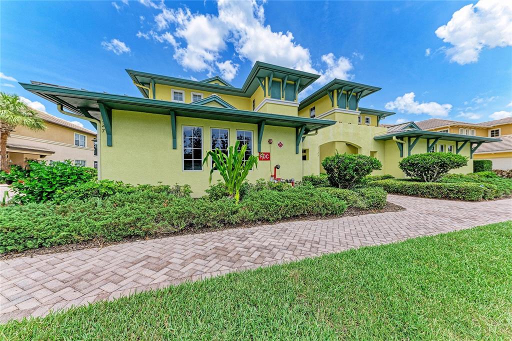 A light green two-story building with a brick walkway and a prominent FDC sign — 1121 RIVERSCAPE STREET UNIT 1121, BRADENTON, FL