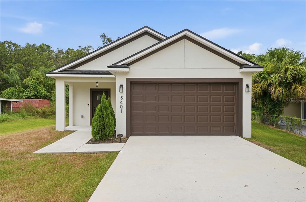 A single-story house with a white stucco exterior, brown trim, and a two-car garage — 5401 OLD CHENEY HIGHWAY, ORLANDO, FL