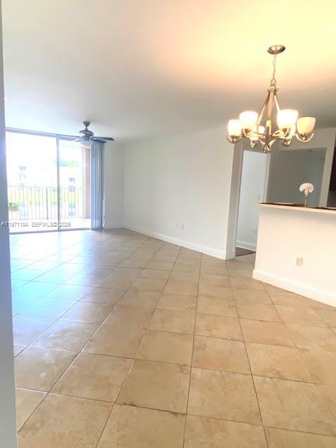 An open living area features beige tile flooring, a chandelier, and a sliding glass door — 2061 Renaissance Blvd # 204, Miramar FL 33025, MIRAMAR, FL