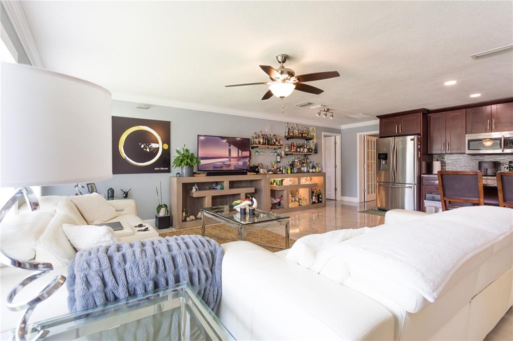 A living room with white leather sofas, a home bar, and an open kitchen — 2198 OAK GROVE DRIVE, CLEARWATER, FL