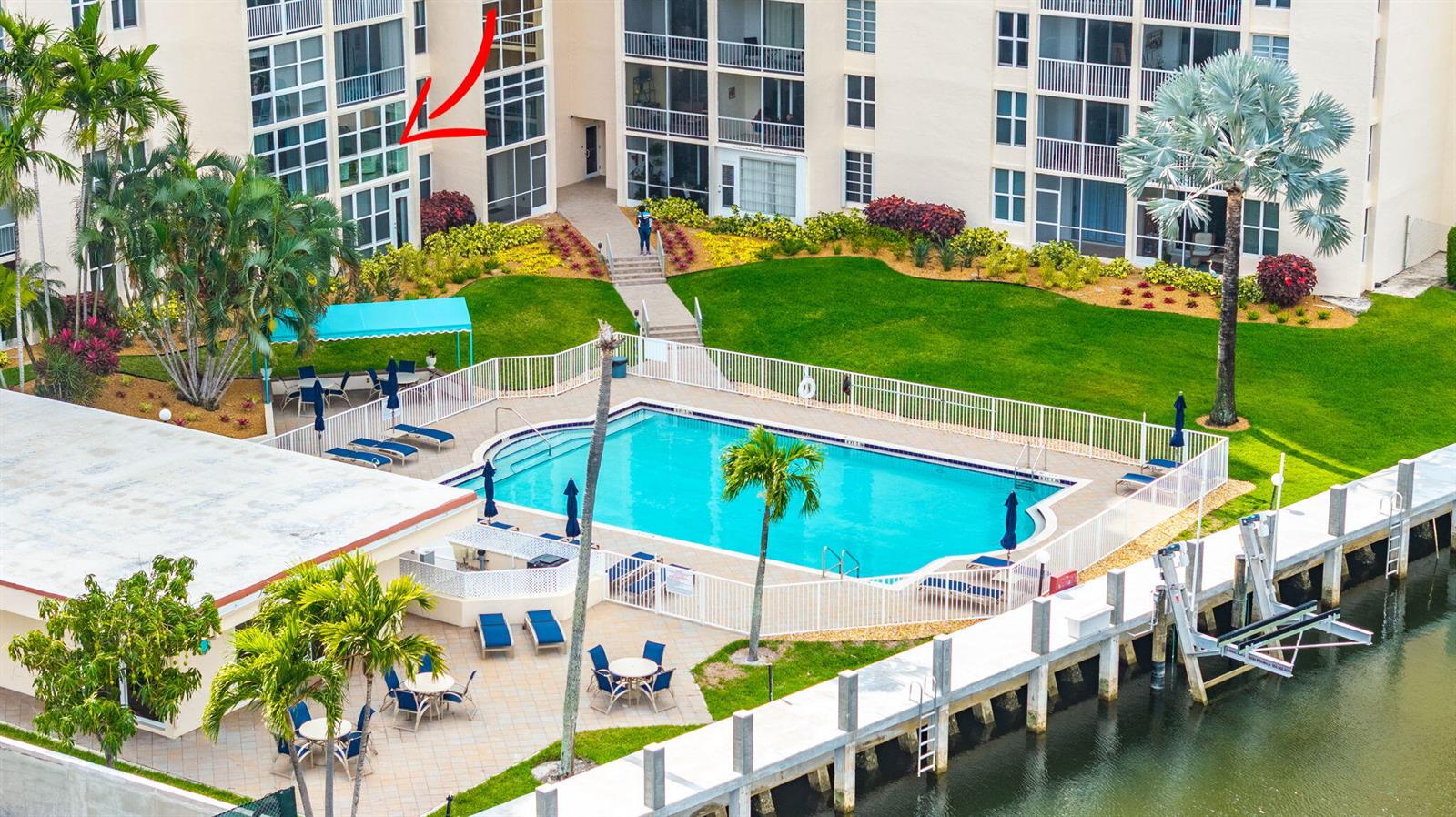 An aerial view shows a swimming pool, patio area, and a canal-side dock — 1391 S Ocean Boulevard # 206, Pompano Beach FL 33062, POMPANO BEACH, FL