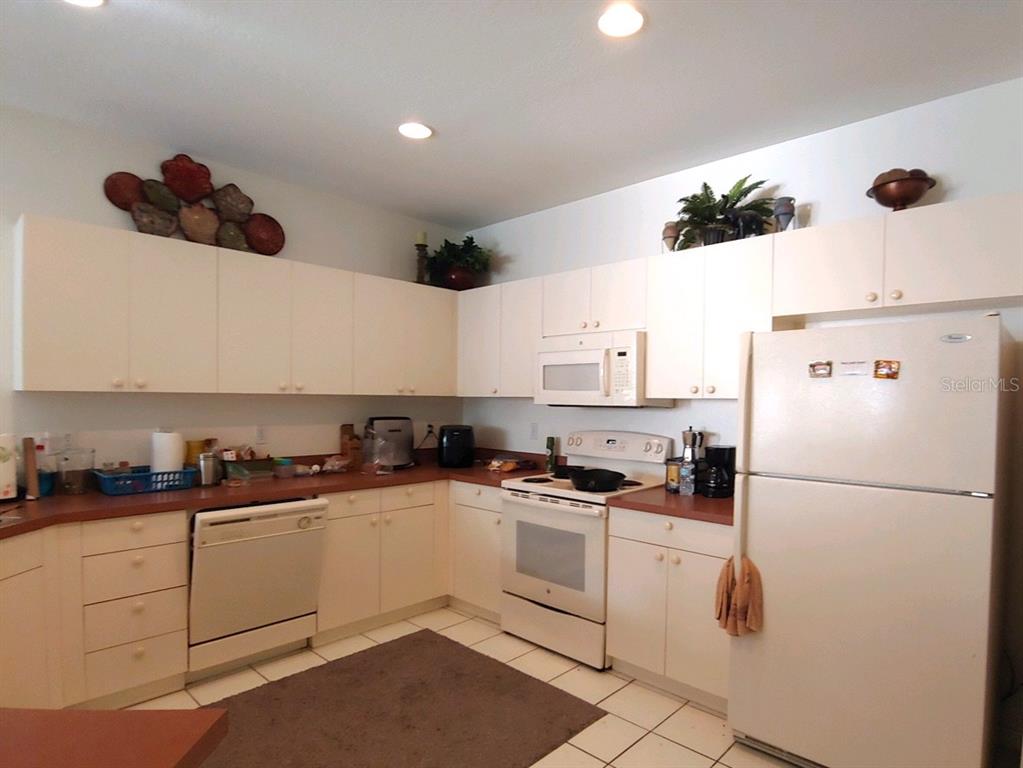 A kitchen features white cabinetry, white appliances, and a dark countertop — 412 W 28TH STREET UNIT 0, PALMETTO, FL
