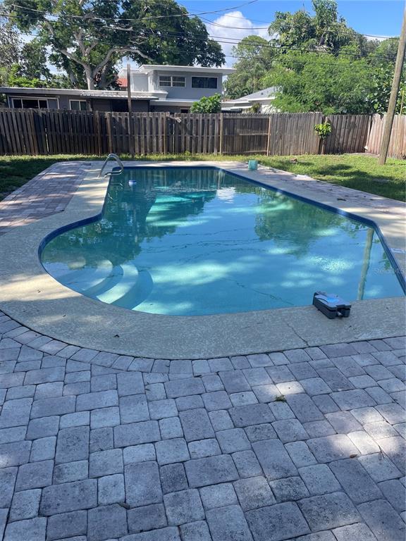 A backyard swimming pool with a paved deck and a wooden privacy fence — 6219 12TH AVENUE S, GULFPORT, FL