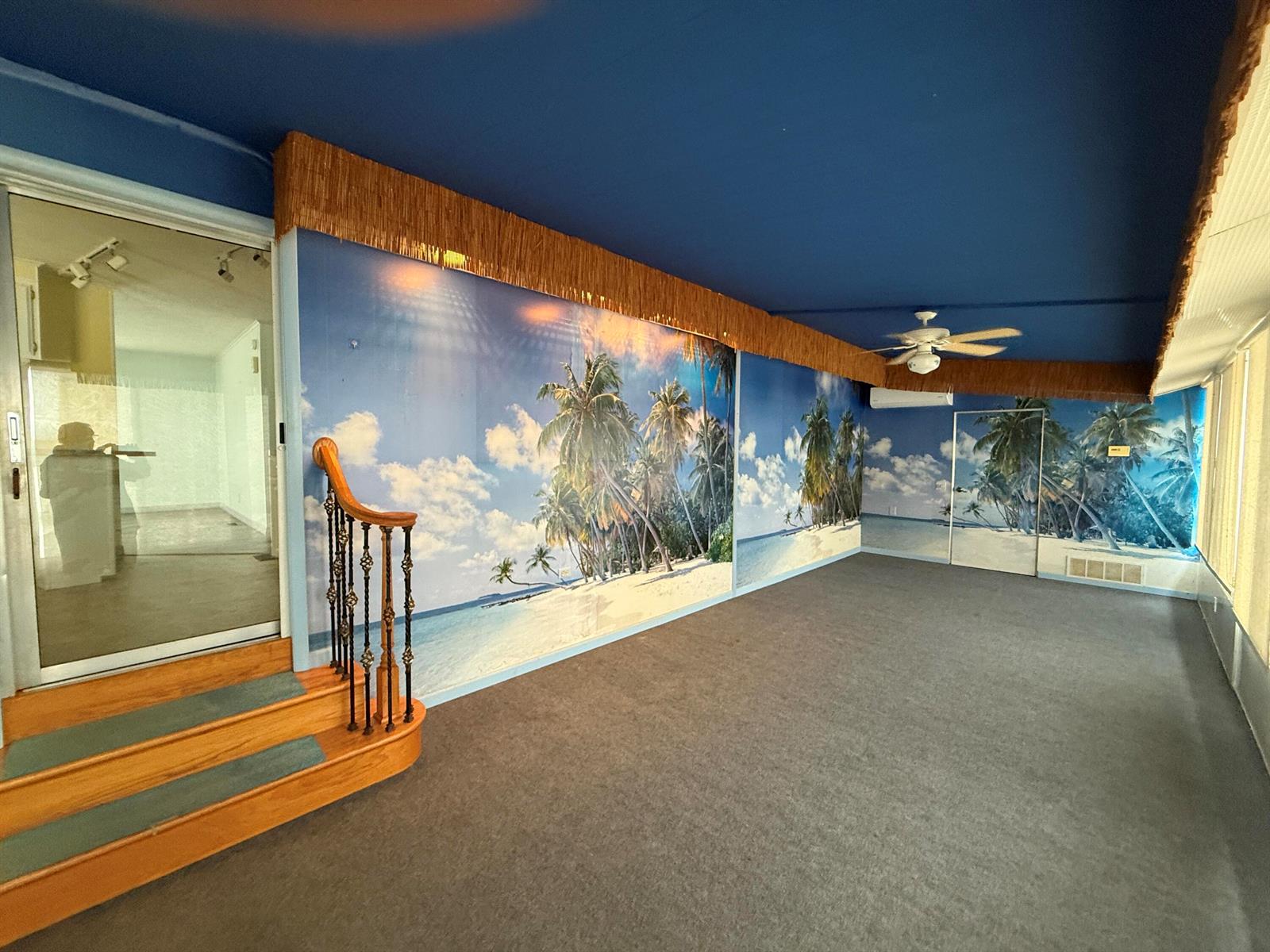 A room with gray carpet, a blue ceiling, and walls featuring a tropical beach mural — 7089 SE Bluebird Circle, Hobe Sound FL 33455, HOBE SOUND, FL