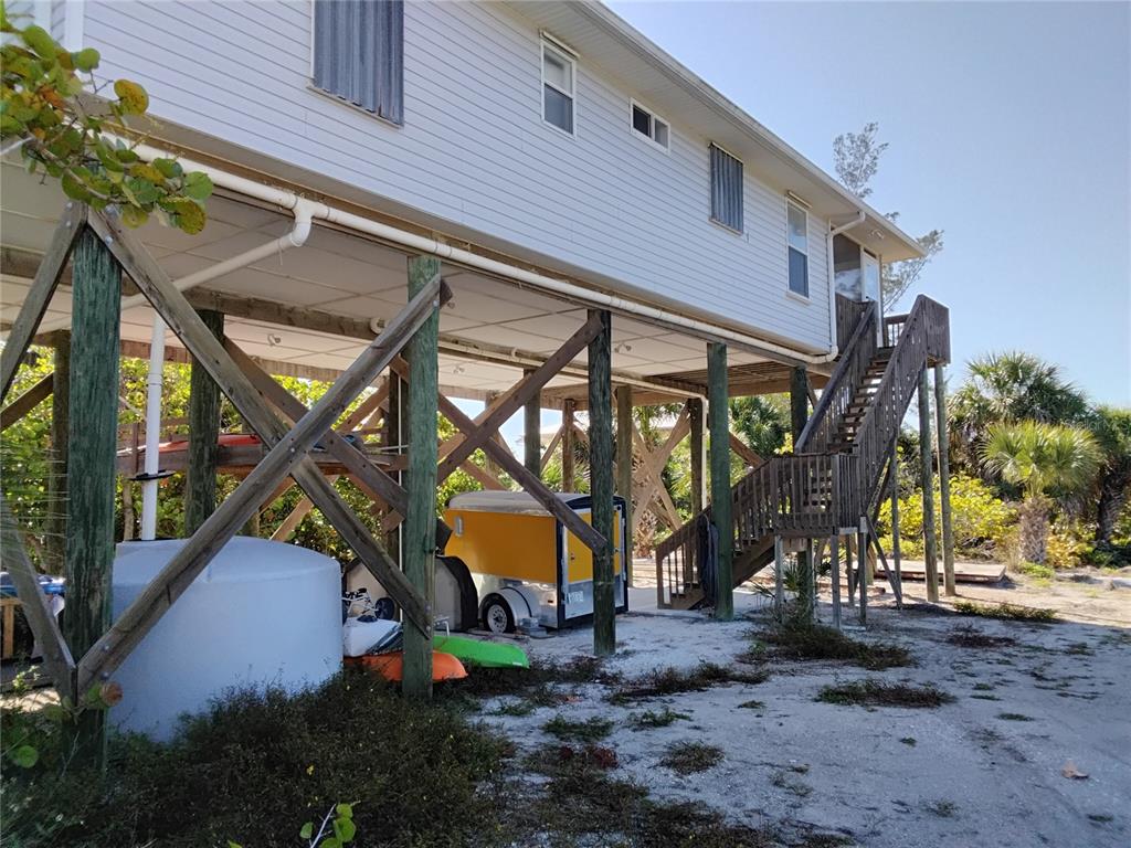 A dirt path leads past a yellow fire hydrant toward a house surrounded by vegetation — 91 GASPARILLA WAY, PLACIDA, FL
