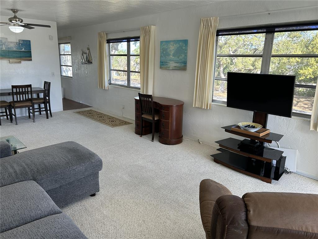 A living room features light carpeting, a television on a stand, and a wooden desk — 4154 57TH STREET N UNIT 274, KENNETH CITY, FL