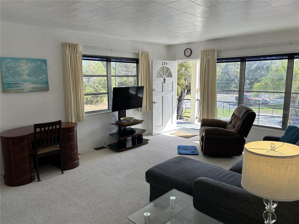 A living room features a desk, television, recliner, sectional sofa, and a glass-topped coffee table — 4154 57TH STREET N UNIT 274, KENNETH CITY, FL